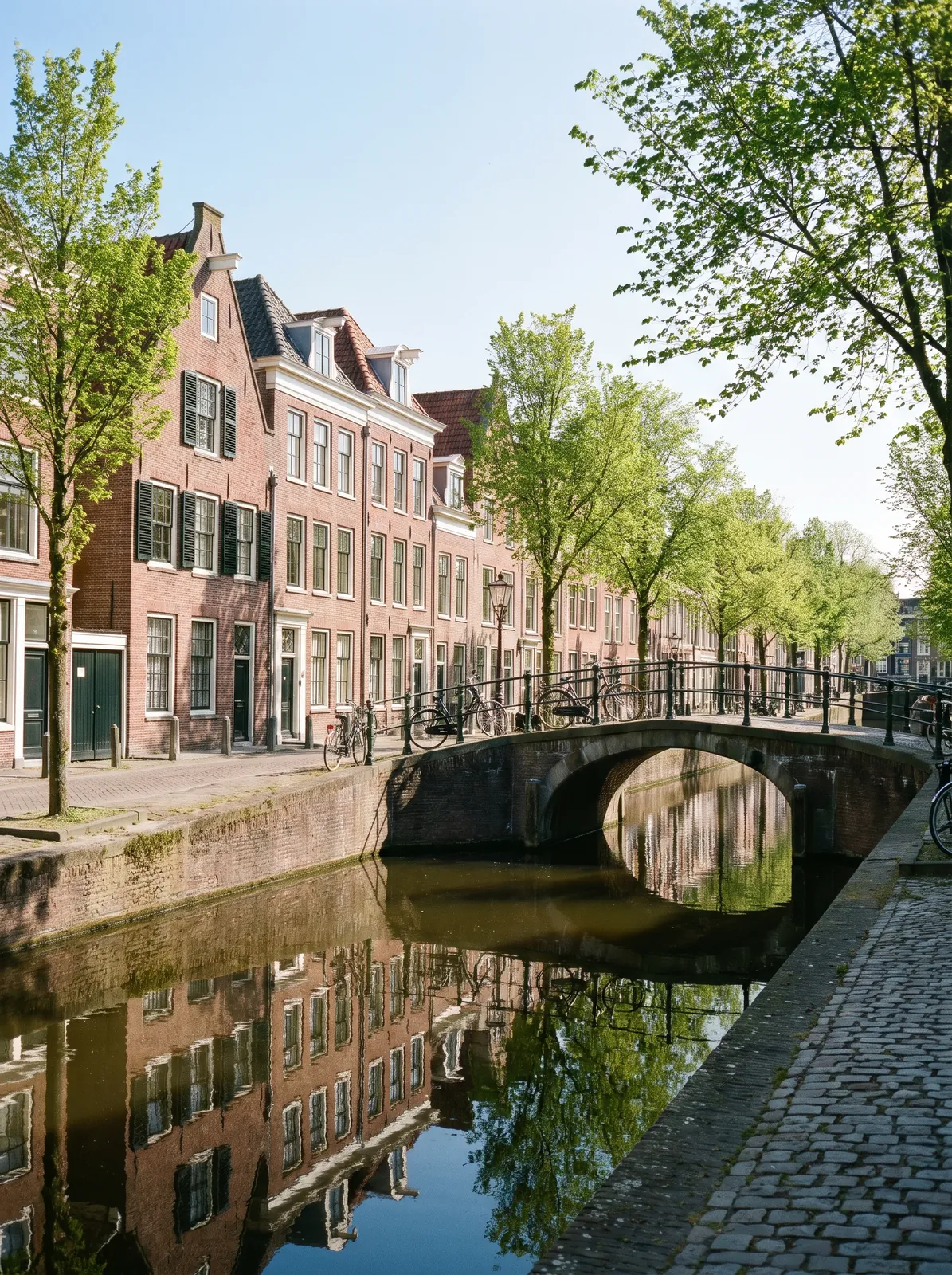 Gracht met bakstenen grachtenpanden en een brug in een Nederlandse binnenstad